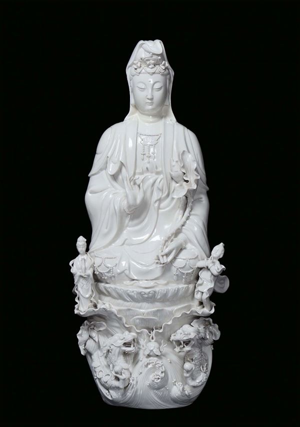A large Blanc de Chine porcelain Guanyin sitting on a cloud with dragons, China, Qing Dynasty, beginning 20th century
