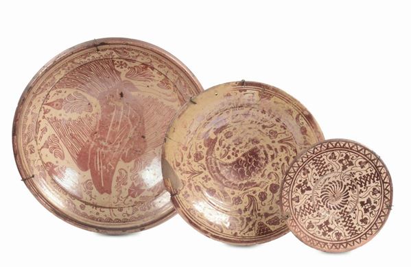Insieme di tre piatti in maiolica con decoro a lustro di gusto ispano moresco, XVII secolo