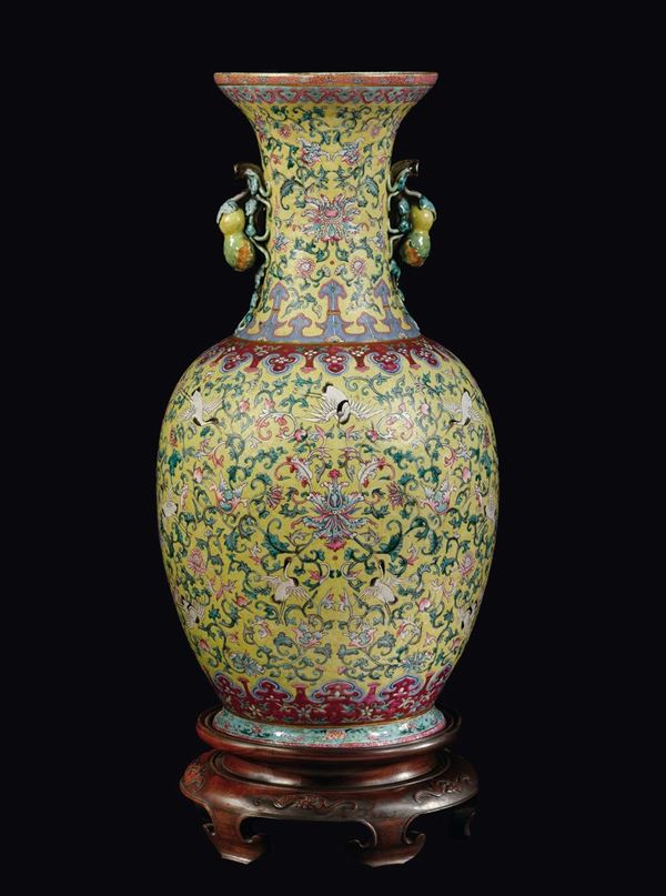 Grande vaso in porcellana a smalti policromi a fondo giallo con decoro di cicogne e anse a doppia zucca  [..]