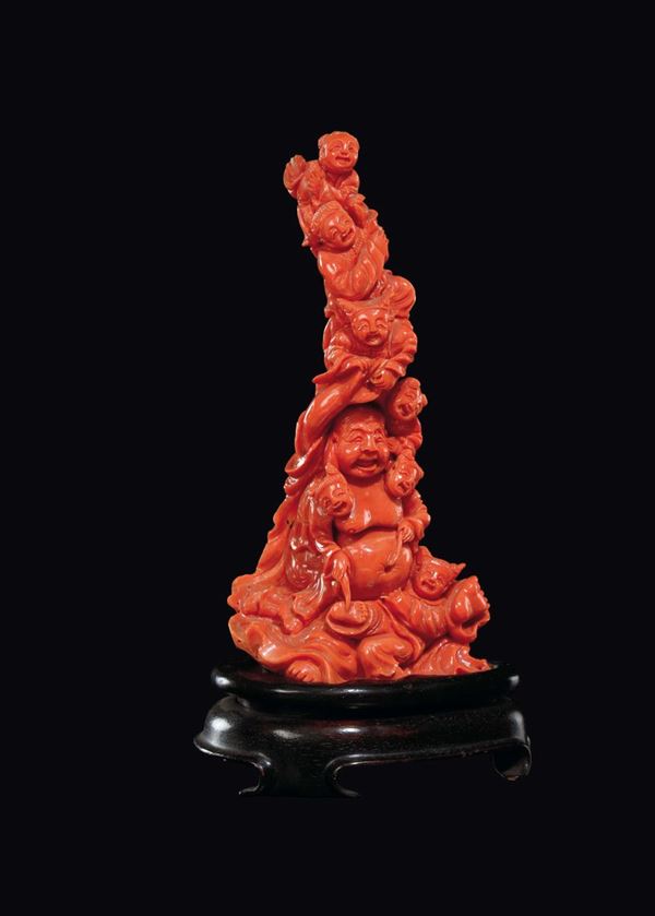 A carved coral Budai surrounded by children group, China, early 20th century