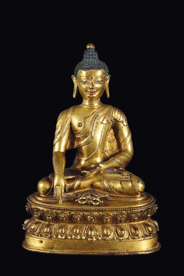 Figura di Buddha Sakyamuni in bronzo dorato con vajra ai sui piedi seduto su doppio fiore di loto, Tibet,  [..]