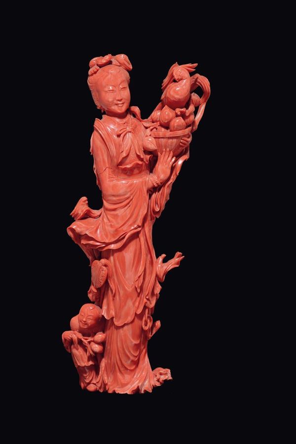 A large carved coral figure of Guanyin with vase and child, China, Qing Dynasty, late 19th century
