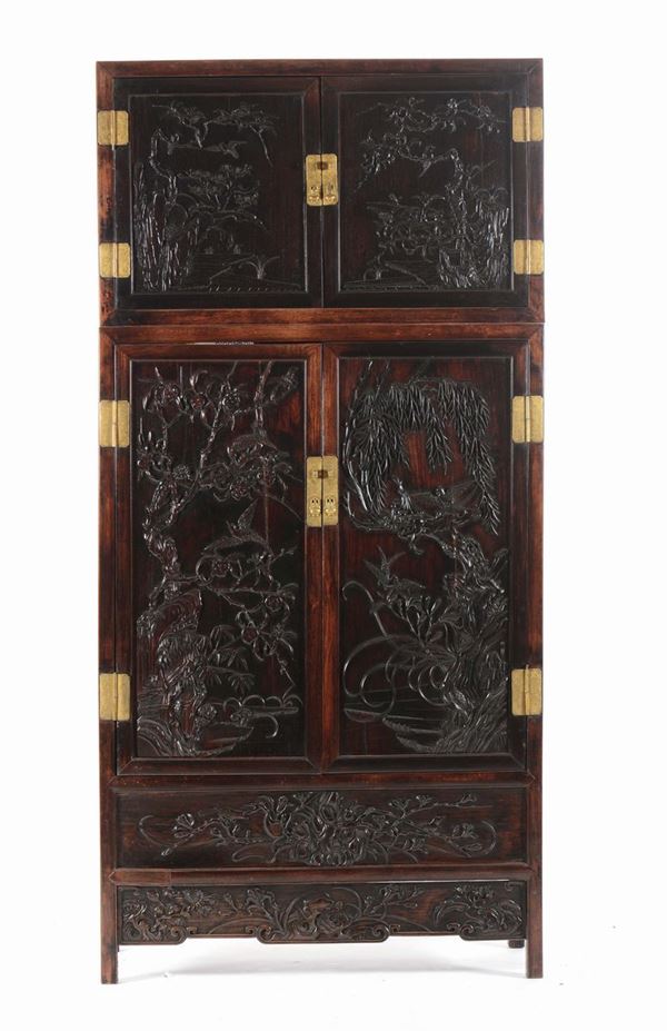 A large and important zitan and huanghuali compound cabinet with finely carved panels, China, Qing Dynasty,  [..]
