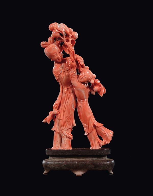 A carved coral Guanyin, child and fruits group, China, early 20th century