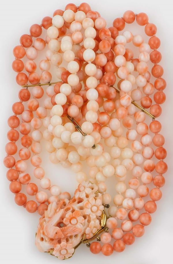 A coral necklace with a carved coral clasp