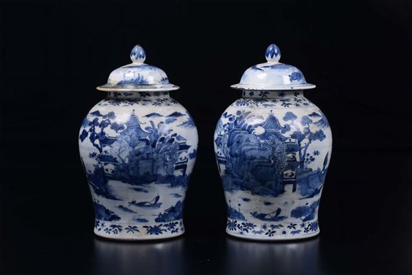 Coppia di potiche con coperchio in porcellana bianca e blu a decoro paesaggistico, Cina, Dinastia Qing, XIX secolo