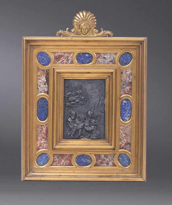 A silver plaque with the Virgin and Child, St. Giovannino and St. Anne. Bronze-gilt frame with lapis  [..]