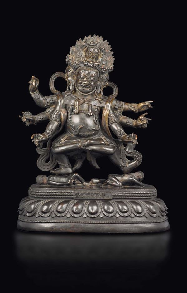 Grande ed importante figura di Mahakala a più teste con oggetti rituali tra le mani sopra fiore di loto,  [..]