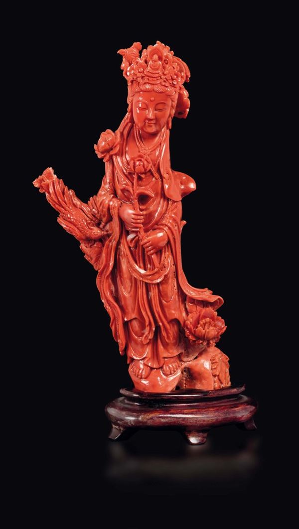 A carved coral figure of Guanyin on a rock with flowers and two phoenixes, China, early 20th century