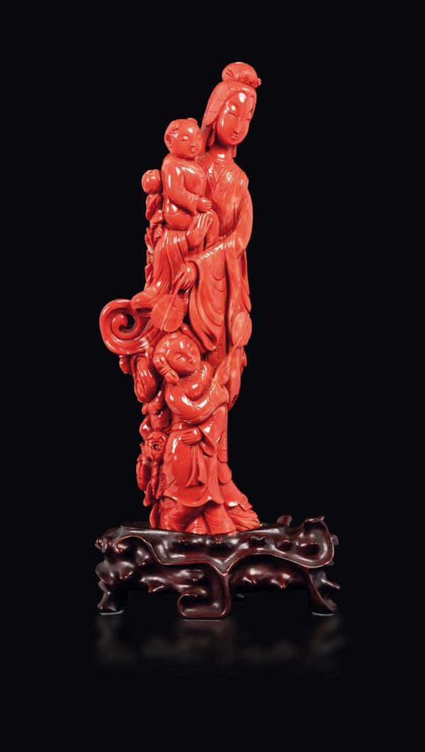 A carved coral figure of Guanyin with two children and two fans, China, Qing, Dynasty, 19th century