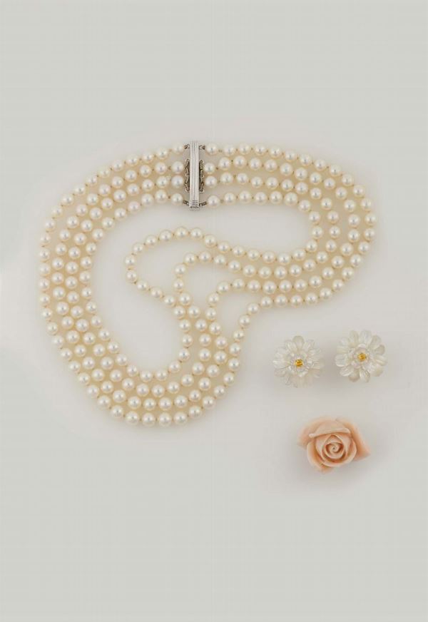 Lotto composto da una collana a quattro fili di perle, un paio di orecchini ed una spilla in corallo