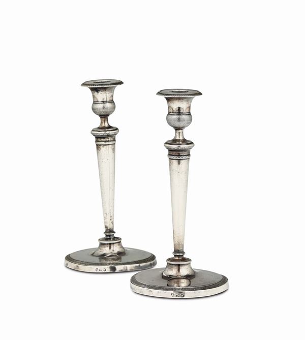 A pair of candlesticks in embossed and chiselled silver, Milan, first half of the 19th century, marks from the Guarantee Office and mark from Giuseppe Sacchi's workshop