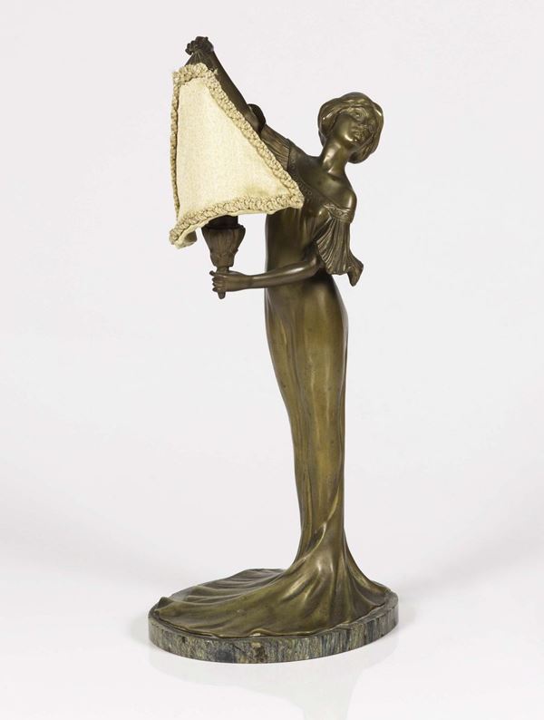 A liberty lamp in gilded brass depicting a woman, on a marble stand