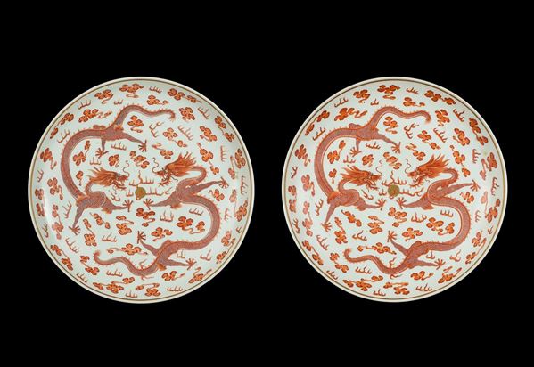 Coppia di grandi piatti in porcellana con decoro di draghi rossi tra nuvole, Cina, Dinastia Qing, marchio  [..]