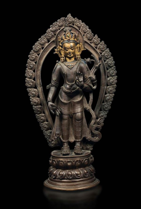 Figura di Avalokitesvara con aura stante su doppio fiore di loto in bronzo con tracce di doratura, Tibet,  [..]