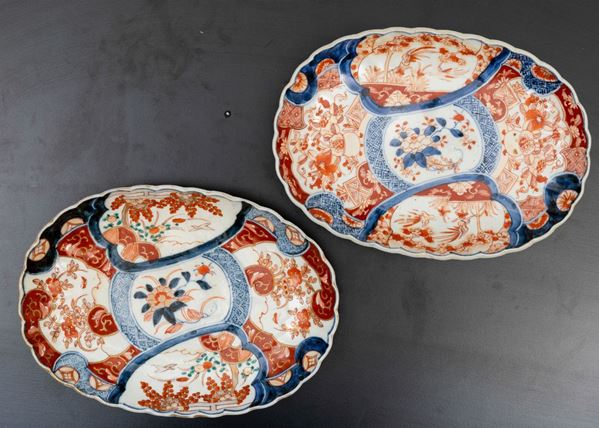 Coppia di piatti ovali in porcellana Imari con decoro floreale e soggetti naturalistici entro riserve, Giappone, periodo Meiji, XIX secolo