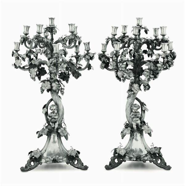 Importante coppia di candelabri in argento fuso, sbalzato e cesellato. Manifattura europea del XIX-XX  [..]