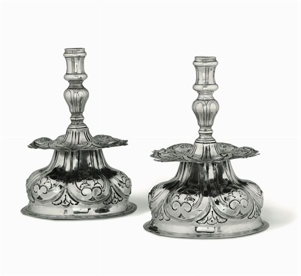 Importante coppia di candelieri in argento fuso, sbalzato e cesellato. Genova, marchio della Torretta  [..]