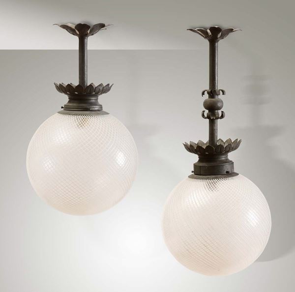 Due lampade a sospensione con struttura in ferro patinato e diffusori in vetro di Murano reticello.