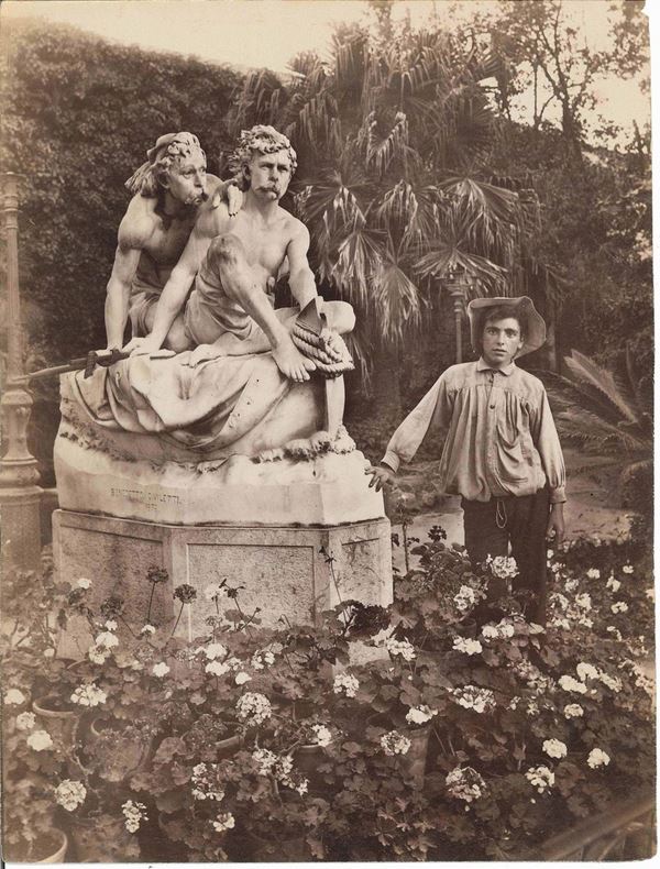 Wilhelm Von Gloeden (1856-1931) Palermo. Ragazzo accanto al gruppo scultoreo dei fratelli Canaris nel Giardino Inglese, 1900 ca