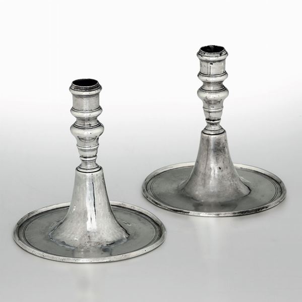 Rara coppia di candelieri in argento fuso, sbalzato e inciso. Genova primo quarto del XVIII secolo.  [..]