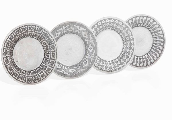Insieme di quattro piattini in argento cesellato con motivi geometrici Art Deco. Colonie Italiane, Tripoli, Scuola orafi Guido Angelini, prima metà del XX secolo