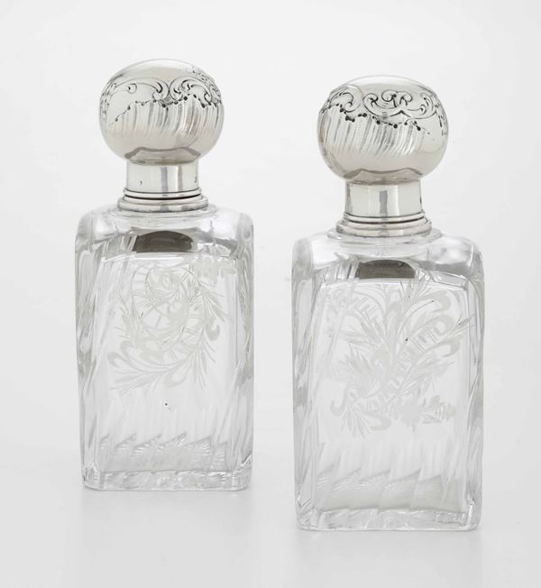 Due bottiglie in cristallo molato con tappo in argento cesellato. Francia XIX-XX secolo