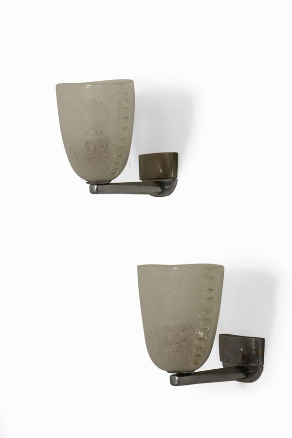 Coppia di appliques con struttura in metallo e diffusori in vetro di Murano.