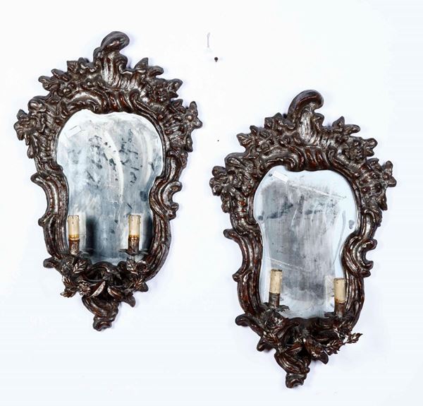 Coppia di candelabri a specchio in legno intagliato, reggiceri metallici con motivi floreali  a doppio braccio, XIX secolo
