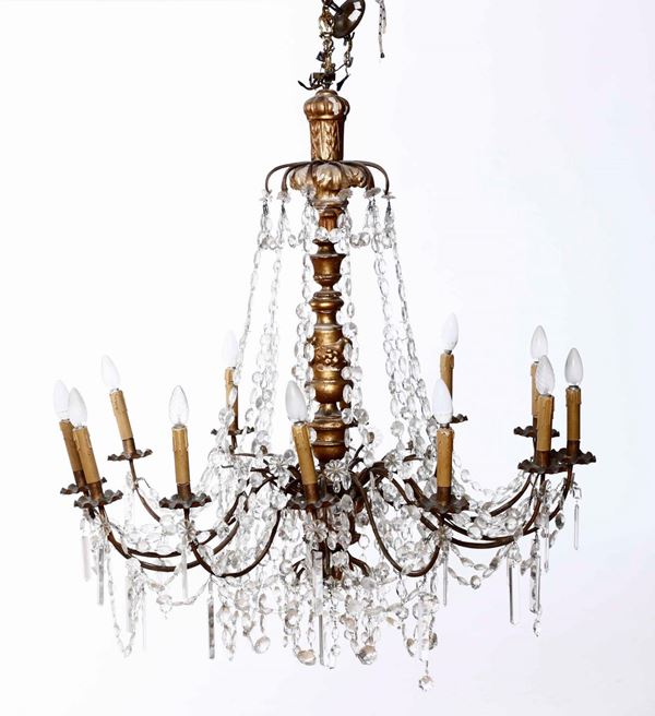Lampadario a 13 luci in legno intagliato, dorato e cristalli a goccia bianchi. XIX secolo