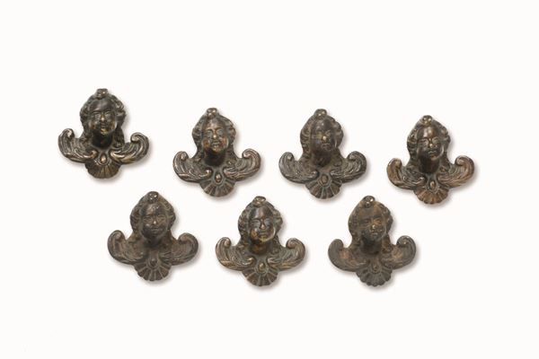 Gruppo di sette maniglie in bronzo fuso e cesellato con teste di cherubini. Italia XVII secolo