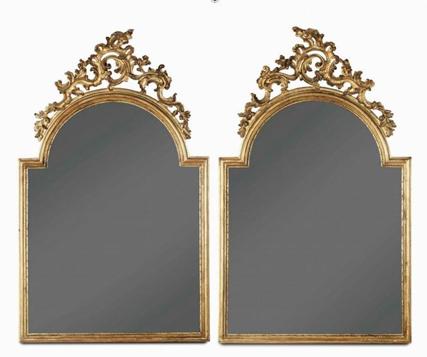 Coppia di specchiere in legno dorato di forma centinata con cimasa intagliata e traforata. XIX secolo